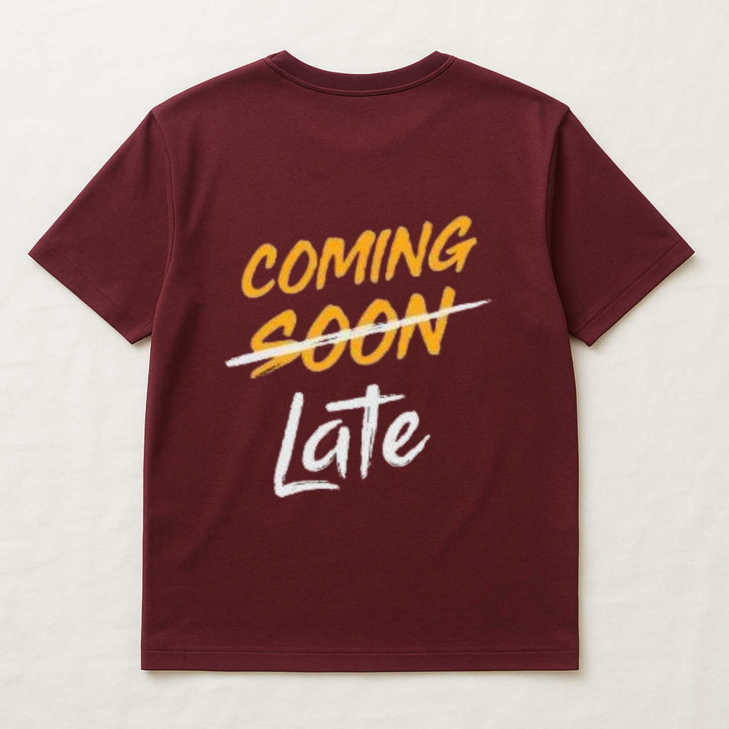 Maroon t-shirt with yellow and white text on a light beige background