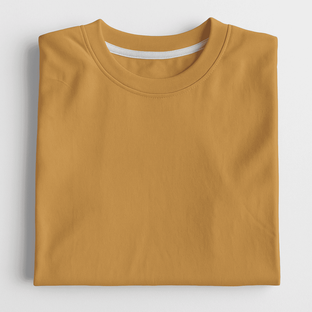 Folded mustard yellow t-shirt on a light gray background