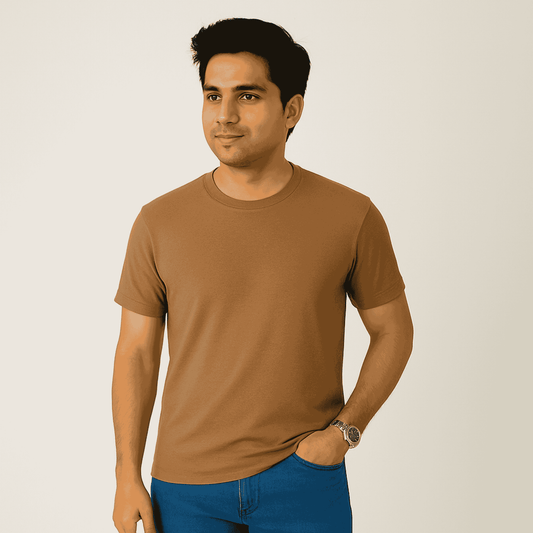 Man wearing a brown t-shirt and blue jeans against a plain background