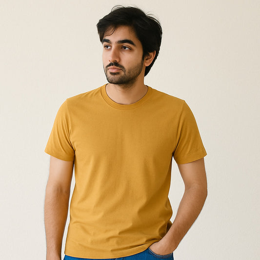 Man wearing a mustard yellow t-shirt against a plain background