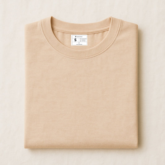 Folded beige sweatshirt with a label on a light beige background