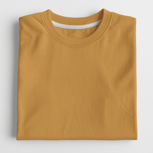 Folded mustard yellow t-shirt on a light gray background
